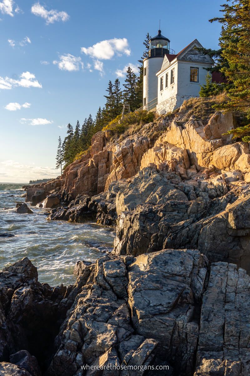 Bass Harbor Head Lighthouse at sunset with water crashing onto rocks