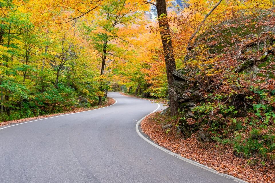 Smugglers Notch pass drive in fall is one of the best things to do in stowe vermont stunning colors winding road up a mountain