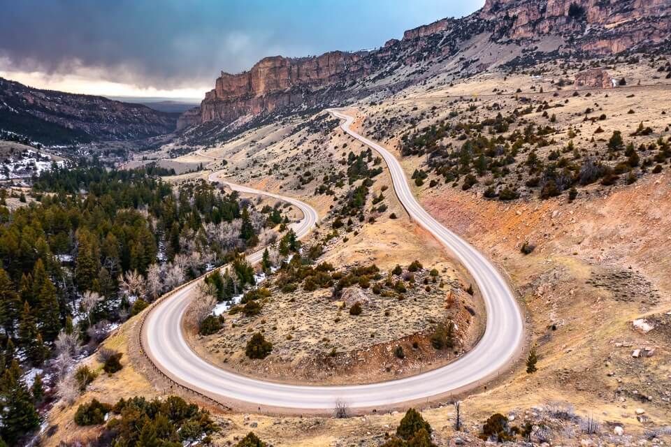 U shaped bend in Cloud Peak Skyway scenic byway in Wyoming taken by drone with clouds in sky