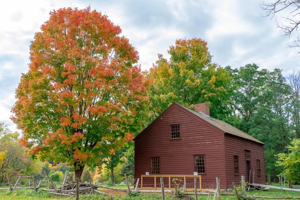 Ethan Allen Homestead wooden structure with gorgeous fall colored leaves in trees surrounding barn one of the best things to do in burlington VT