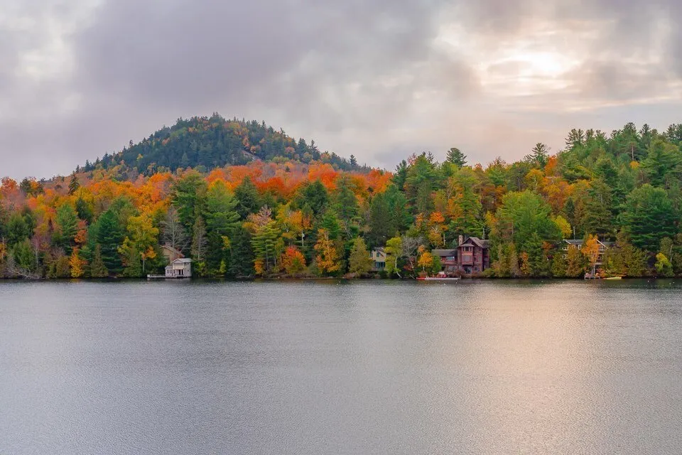 Lake Placid New York is one of the best places to stop on a fall new england road trip mirror lake stunning colors and clouds