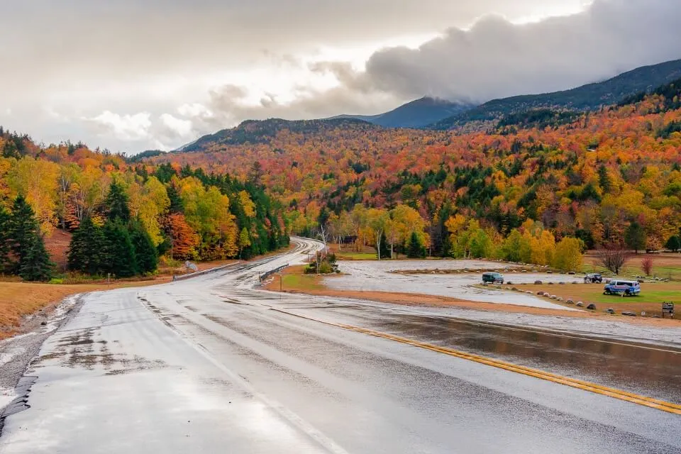 Mount Washington in New Hampshire down road and colors in trees with cloudy sky