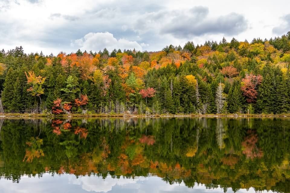 Reflecting lake with trees on Kancamagus Highway in New Hampshire