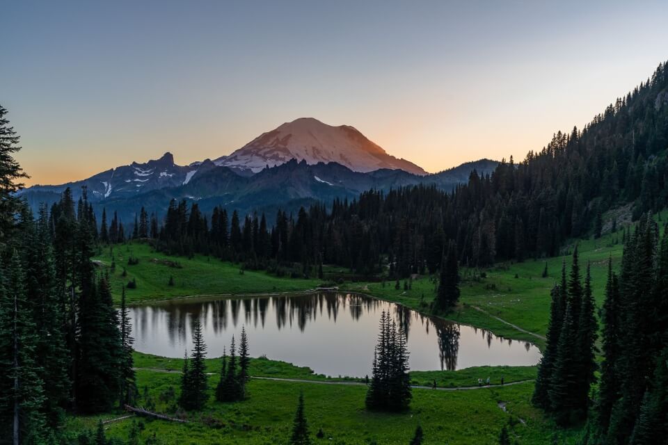 Mt Rainier reflecting in Tipsoo Lake at sunset with orange sky on naches peak loop trail