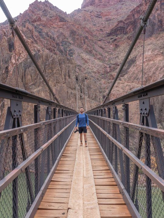 Hiking over the colorado river on black bridge in december with shorts and t shirt