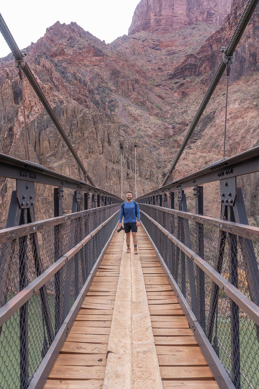 Hiking over the colorado river on black bridge in december with shorts and t shirt