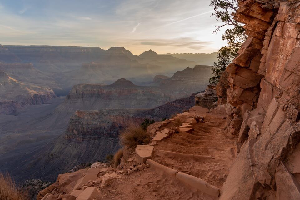 Stunning sunrise beams hiking down south kaibab trail one of the best day hikes at grand canyon south rim