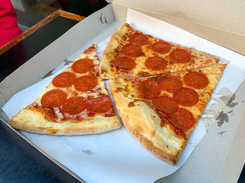 Three large slices of New York style pizza in a cardboard box