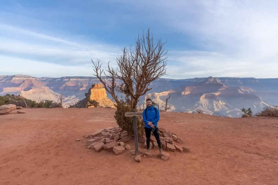 Hiker stood next to a dead tree inside grand canyon national park