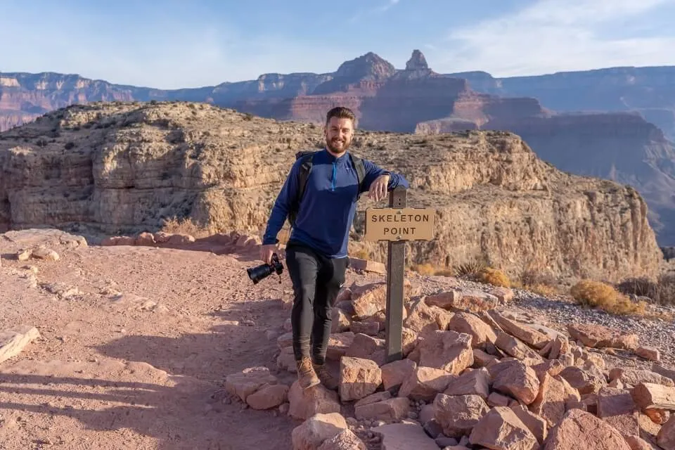 Hiking South Kaibab Trail to Skeleton Point Grand Canyon sign and hiker with camera in arizona