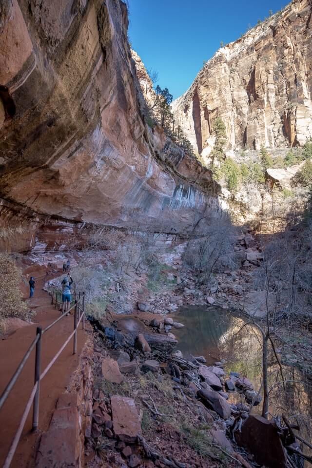Lower emerald pool trail under huge rock canyon ledge in zion national park utah