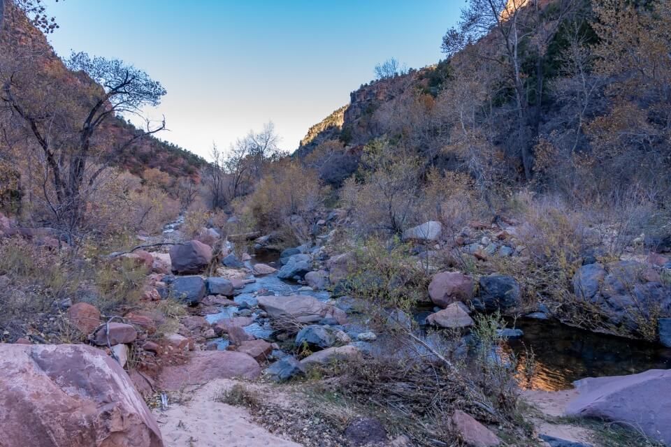 Rocks and boulders alongside a river on a bright blue day in utah