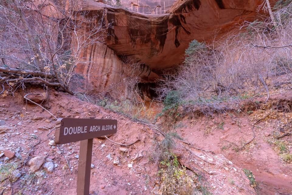 Sign leading to double arch alcove on a hike in utah