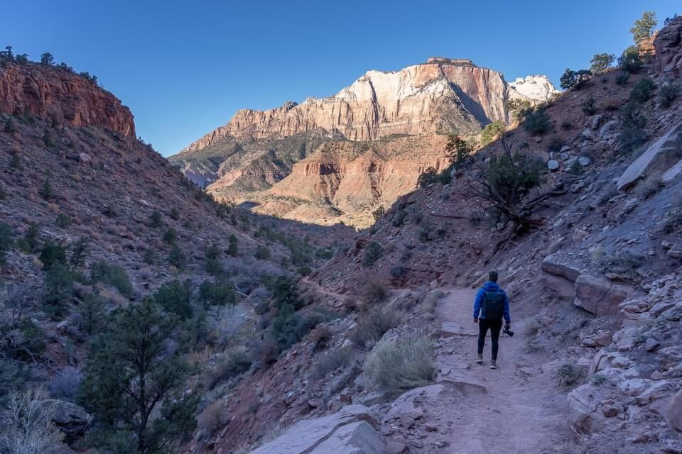 Descending a hike between rocks at sunrise in utah