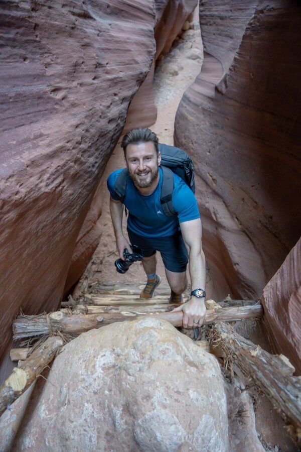Man climbing ladder from above inside a wafer thin canyon