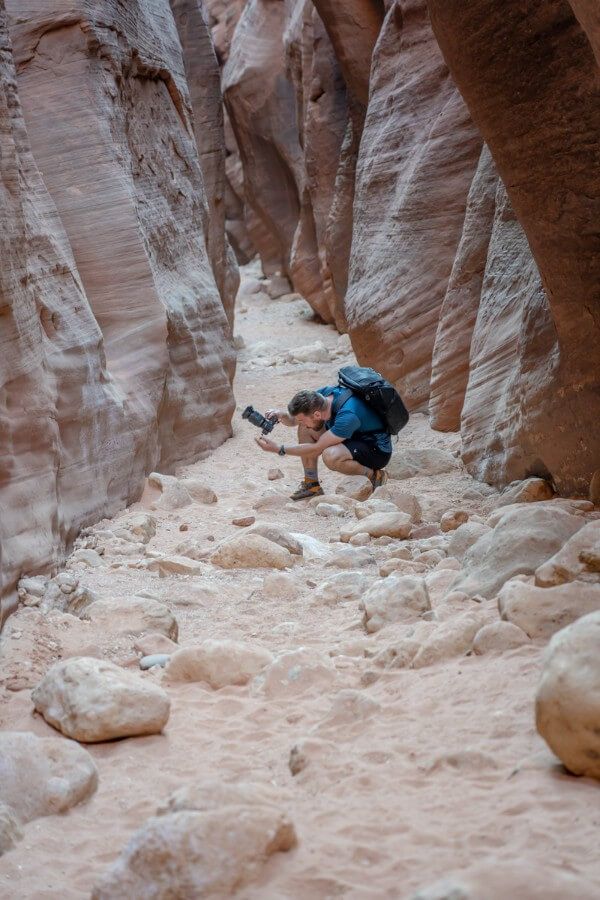 Taking photos of canyon walls on a sandy path