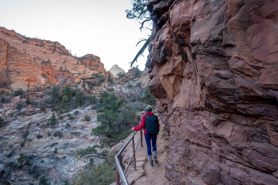 Hiking with barrier into an arid orange rocky landscape