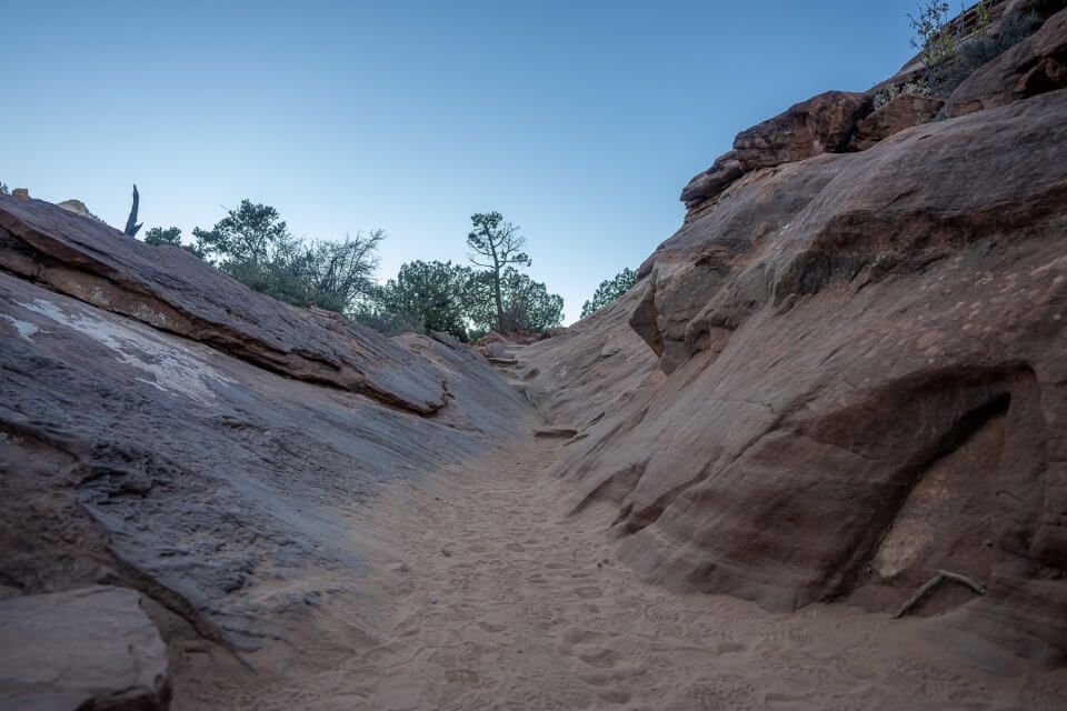 Sandy trail leading through rocks at dusk in utah