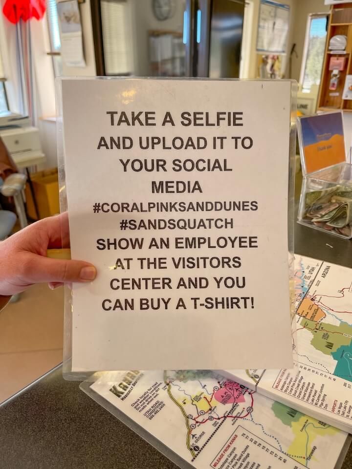 Laminated sign showing how to take a selfie and upload to socials for chance to discount clothing