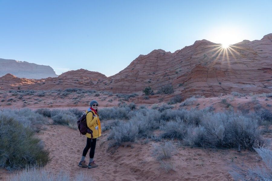 Hiking down a sandy trail to The Saddle right after sunrise on the hike to The Wave in Arizona