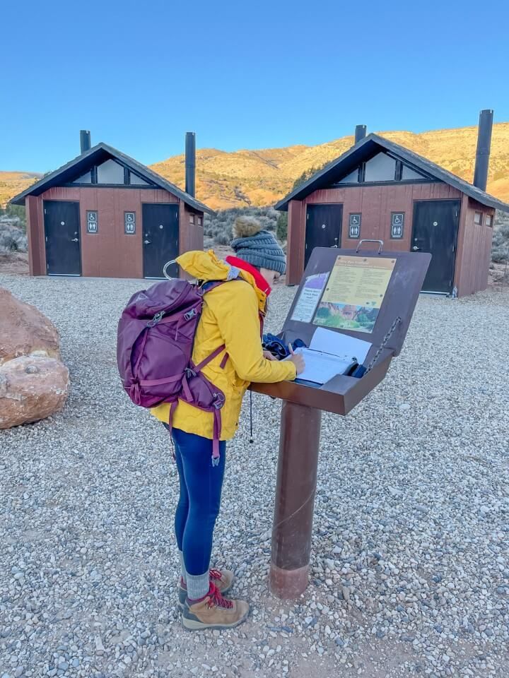 Hiker registering for a hike wilderness permit sign in