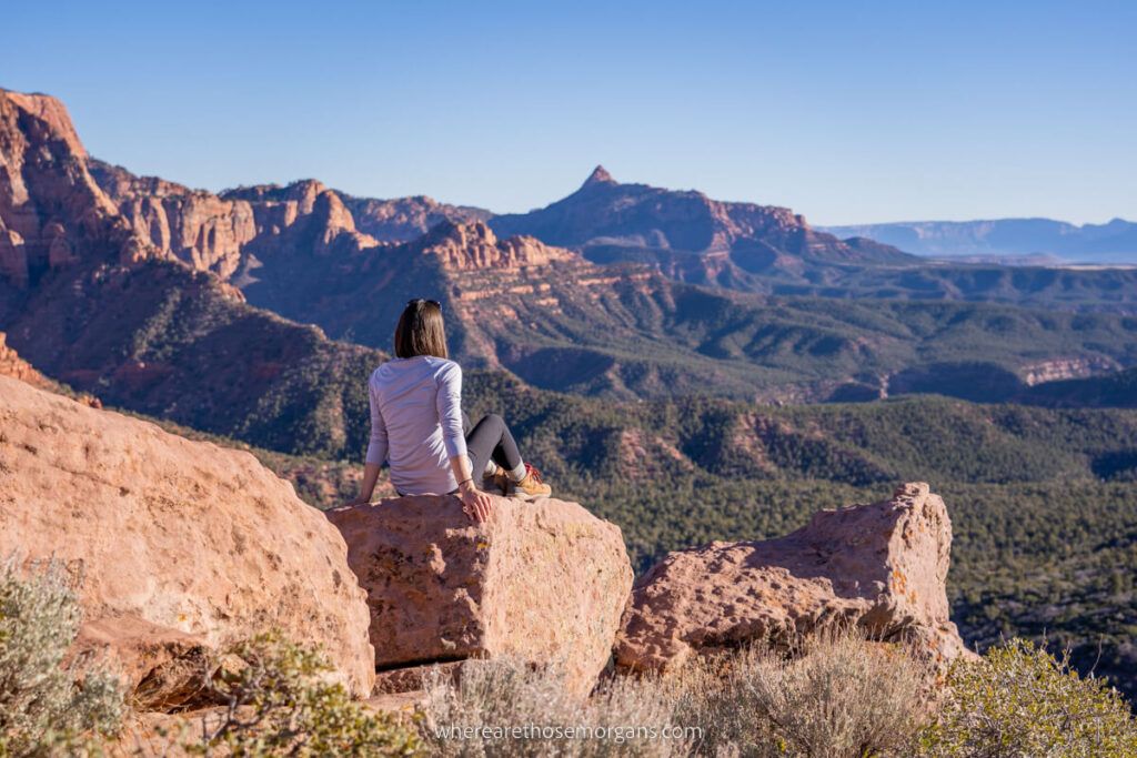 Woman relaxing on a rock looking at far reaching views over Kolob Canyons