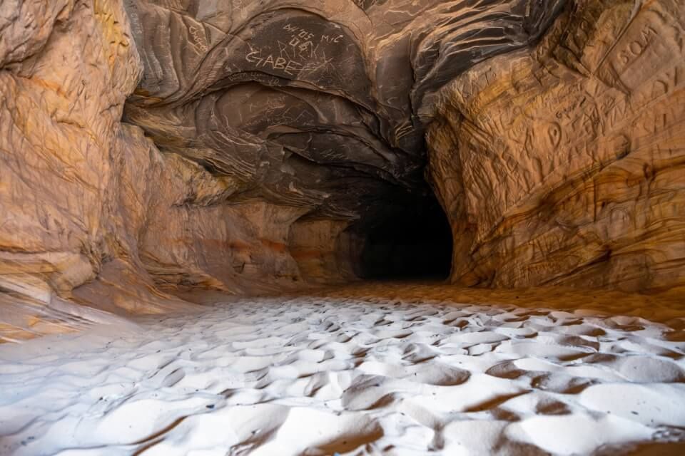 Dark shadows at the end of a tunnel in orange rocks