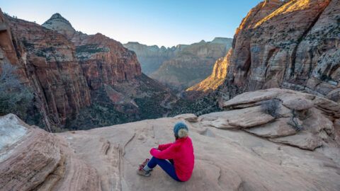 Hiker enjoying sunset views at the summit of Zion Canyon Overlook Trail on a one day in Zion National Park itinerary in Utah