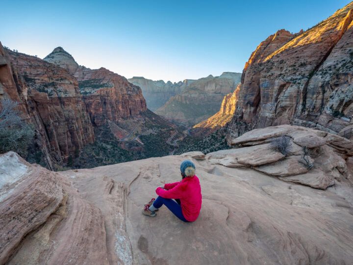 Hiker enjoying sunset views at the summit of Zion Canyon Overlook Trail on a one day in Zion National Park itinerary in Utah