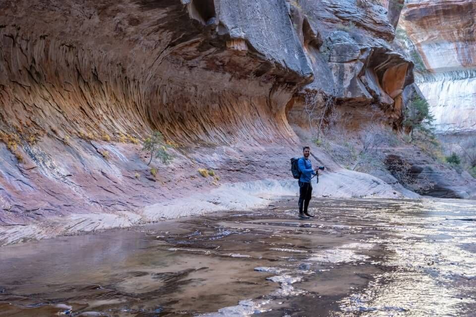 Hiking with camera in The Subway Trail in Utah smooth tunnel like rock formation in shadow