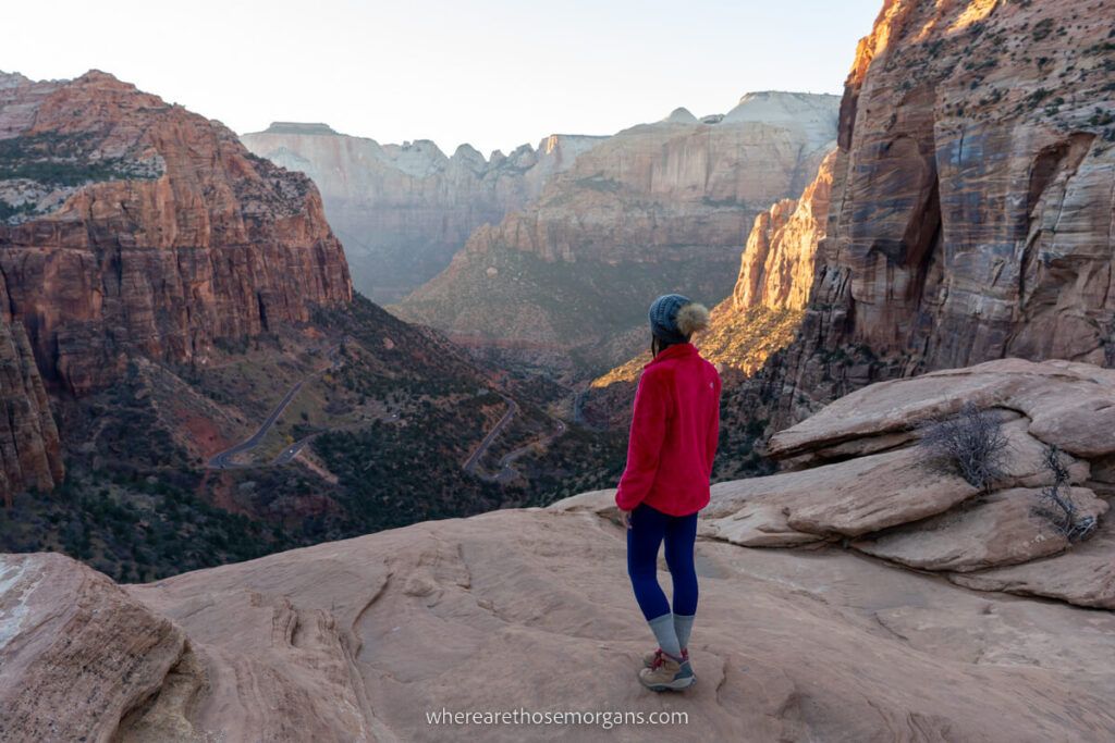 Woman standing at a beautiful vista during sunset after a short hiking trail in Zion national park