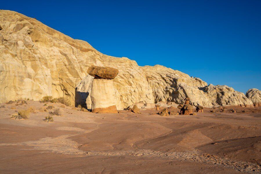 Yellow rock face covered in yellow light around sunset with deep blue sky