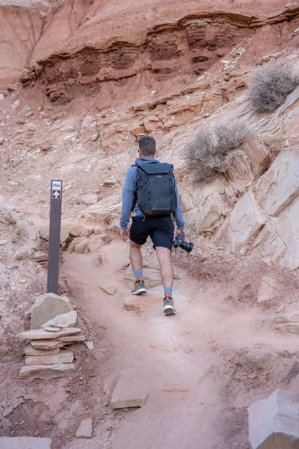 Hiking on a dirt packed trail with a camera