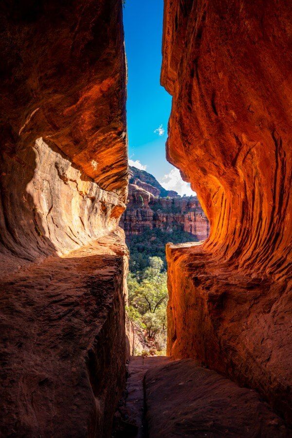 The Subway Cave in Sedona Arizona glowing orange under mid morning sunlight