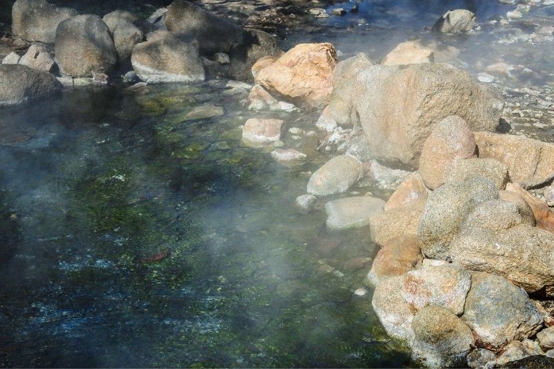 Hot stream swirling around large rocks at a Northern California hot spring