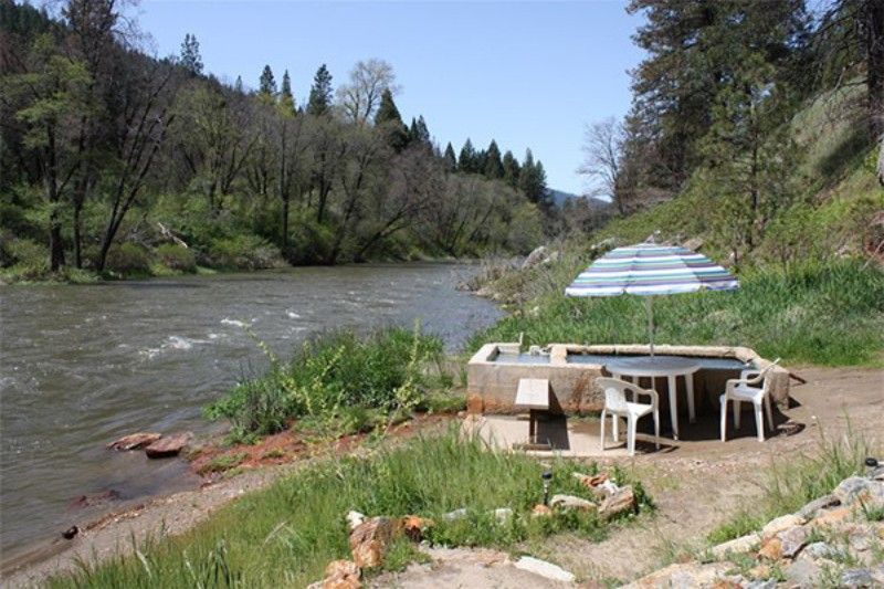 Feather river hot spring pool with umbrella and chairs for visitors
