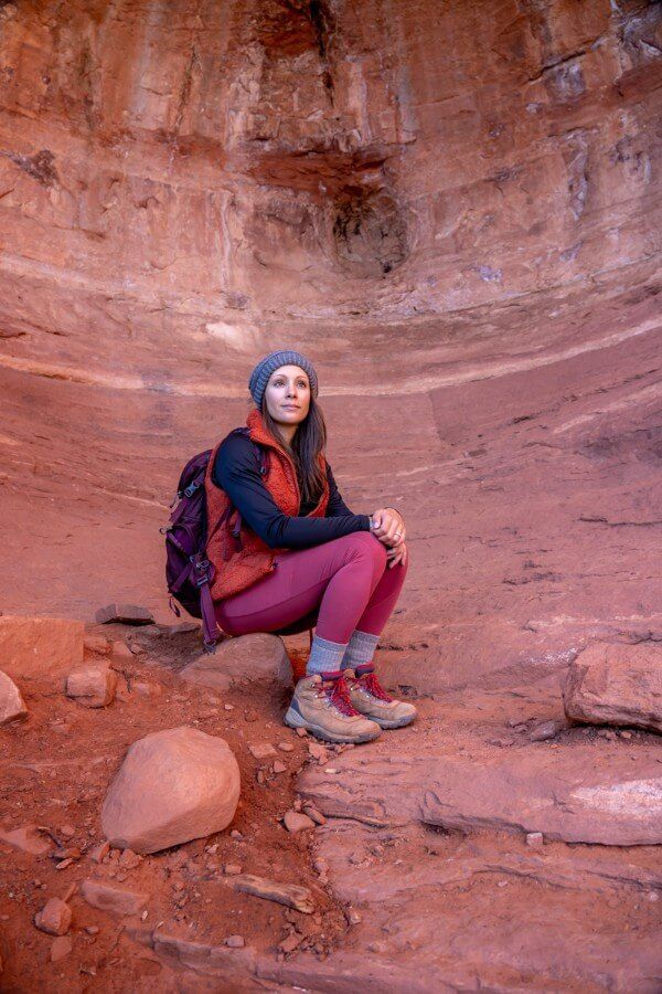 Hiker sat on a small stone at the entrance to Birthing Cave in Sedona