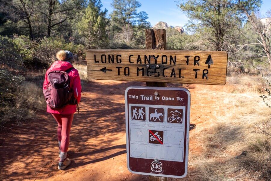 Hiker walking past a trail intersection in Arizona