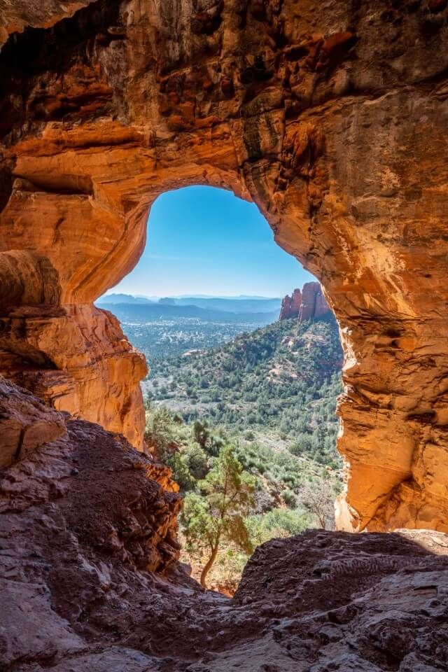 Looking out through a sandstone rock formation at blue sky