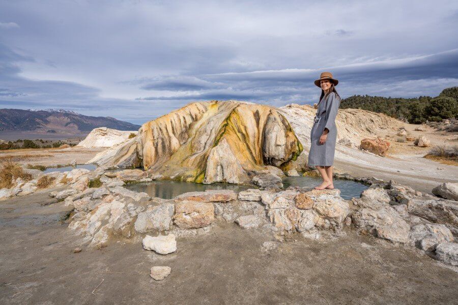woman in robe and hat at Travertine hot spring in northern california