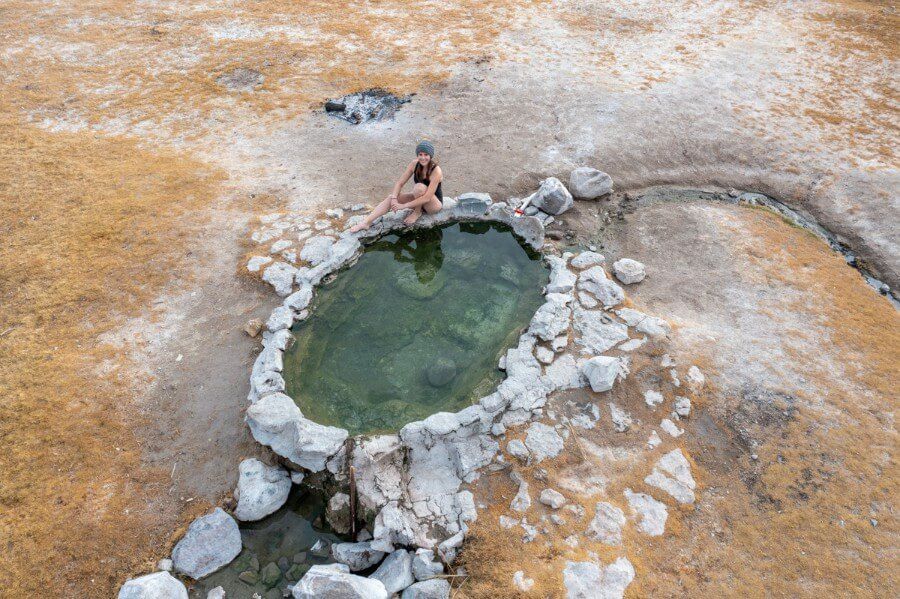 Drone shot of woman bathing in crab cooker hot spring