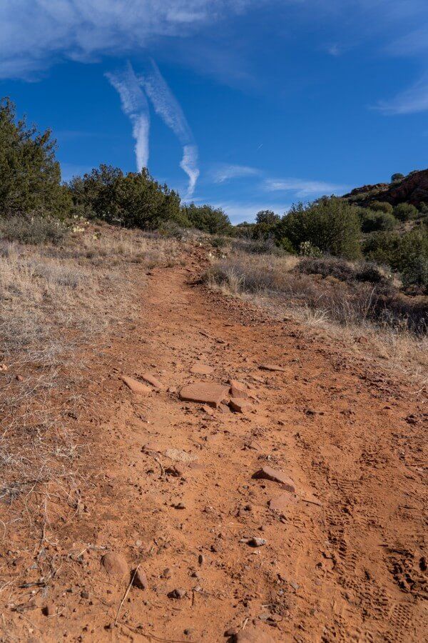 Steep uphill bank on a dirt trail with blue sky background