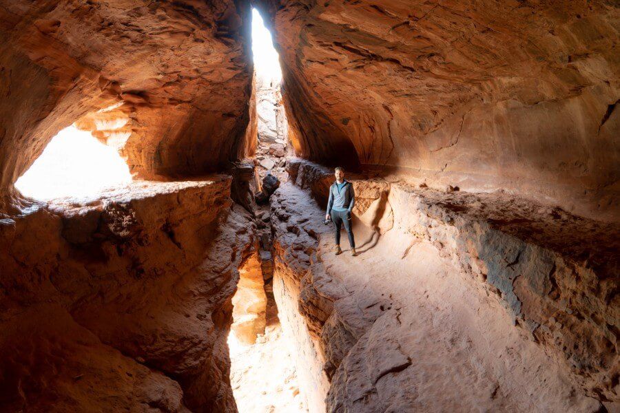 Hiker with camera inside cave with three light sources Soldier Pass Trail Sedona