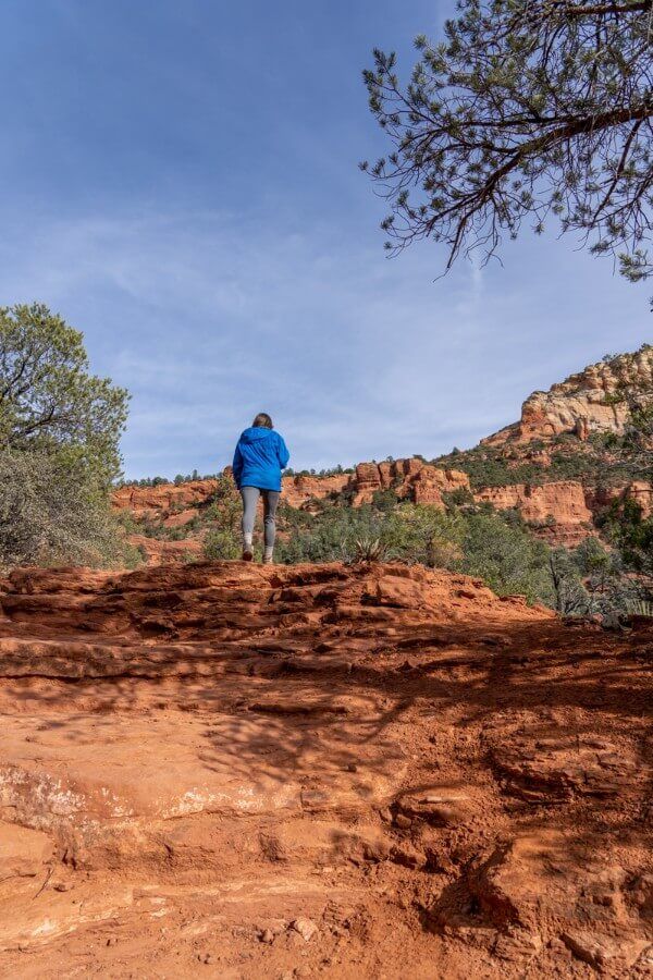 Hiker climbing red rock steps on a cold but sunny day