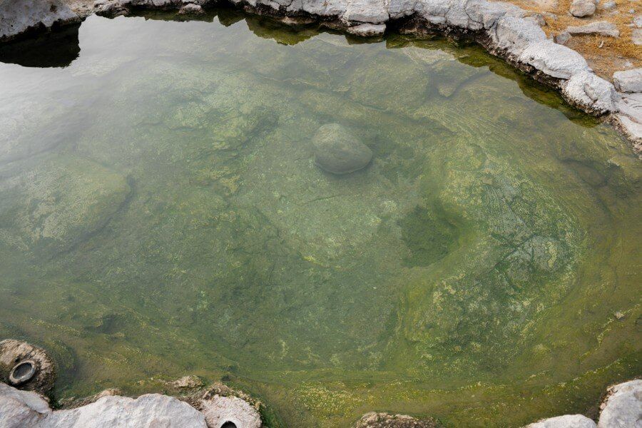 Water in hot spring pool from above showcasing a rock bottom