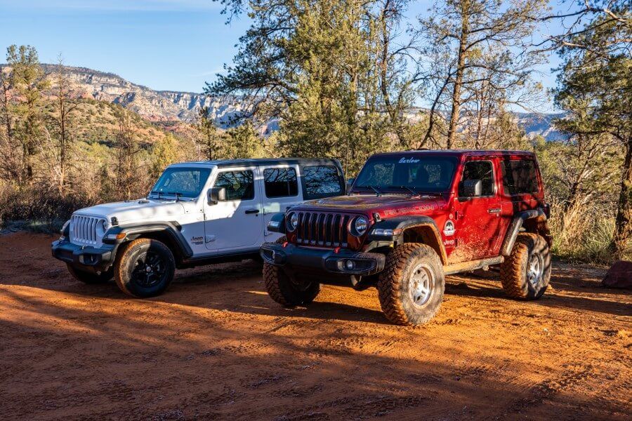Jeeps parked in the Devils Bridge Trail trailhead parking lot right after sunrise in Sedona Arizona