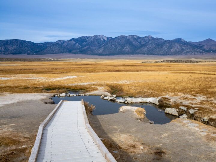 A beautiful view of wild willy's hot spring with mountains in the distance