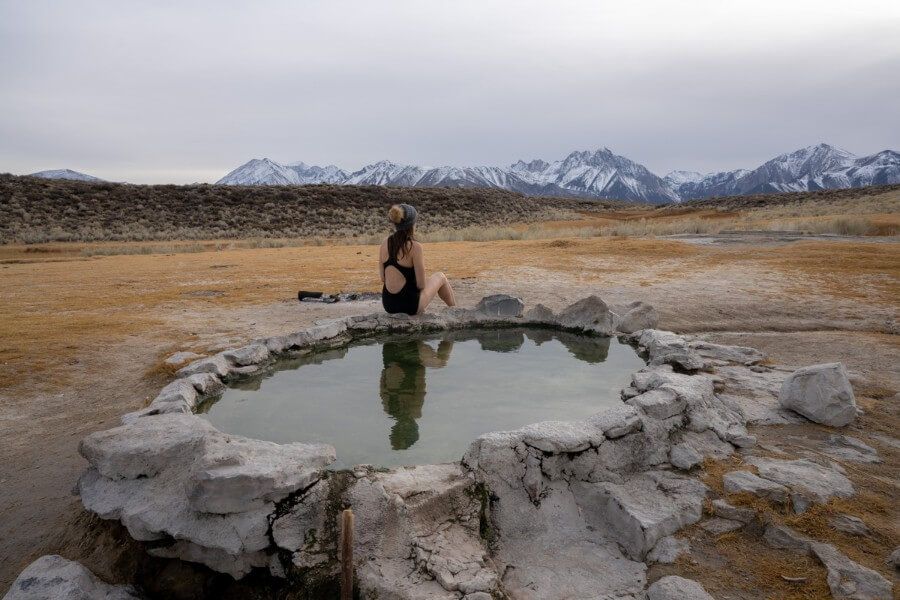 Crab cooker hot spring with woman sitting on edge of pool