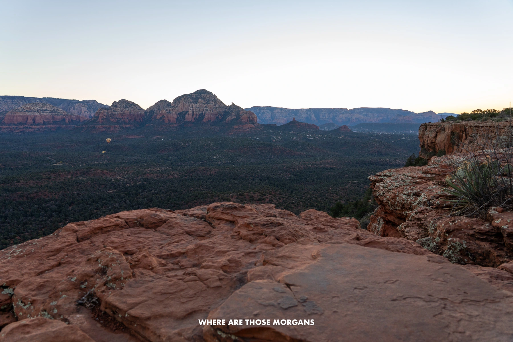 Photo of a valley and red rock cliffs view from the summit of Doe Mountain Trail in Sedona before sunrise