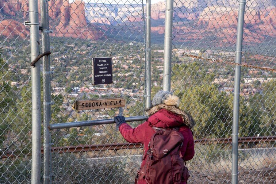 Hiker pushing through gate to access path in Arizona